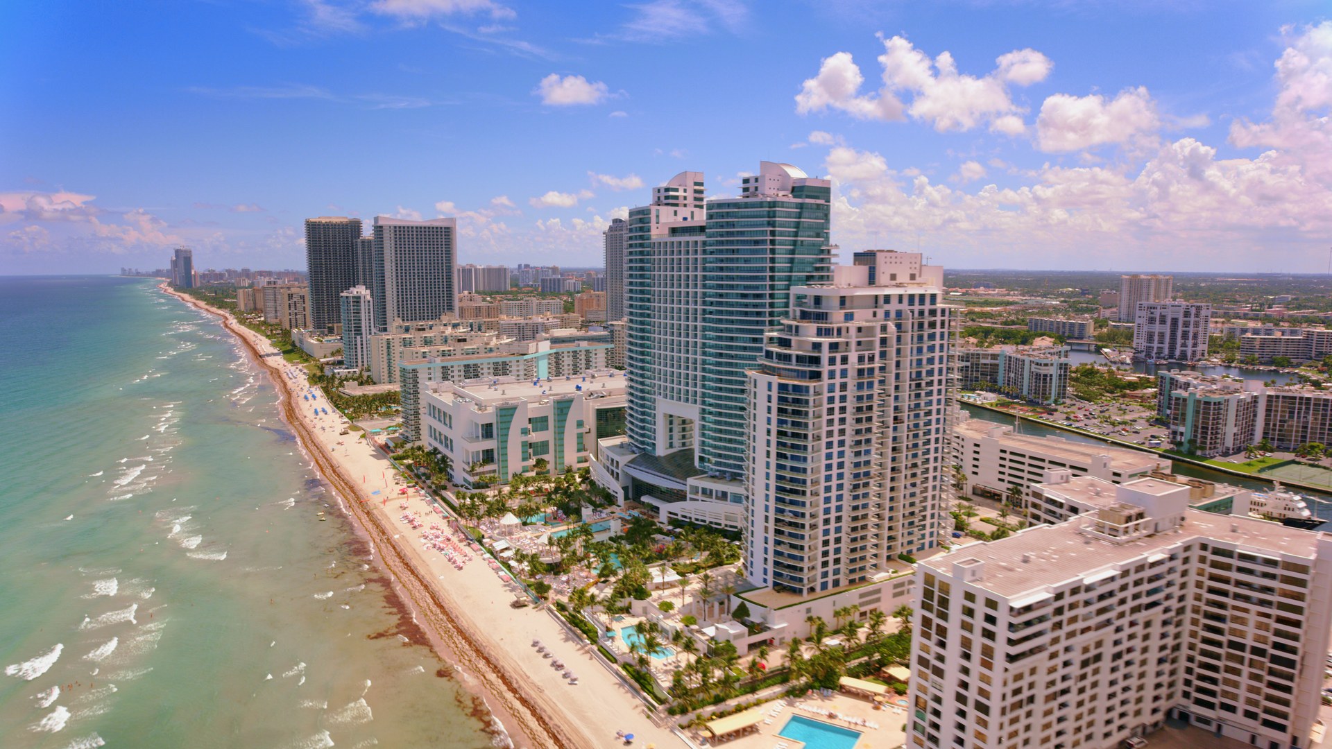 An aerial view of the Hollywood Beach skyline with luxury high-rises and a vibrant beachfront